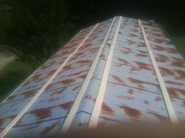 Rusted metal roof panels with new wood purlins before replacement — Storm Damage Roof Repair in San Lorenzo by Roofing Brothers