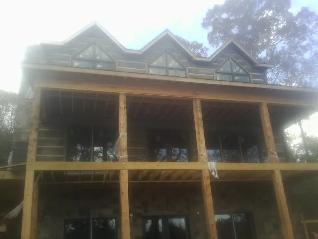 Dormers and porch framing on a large log home under construction — Roof Coating work by our crew in San Lorenzo