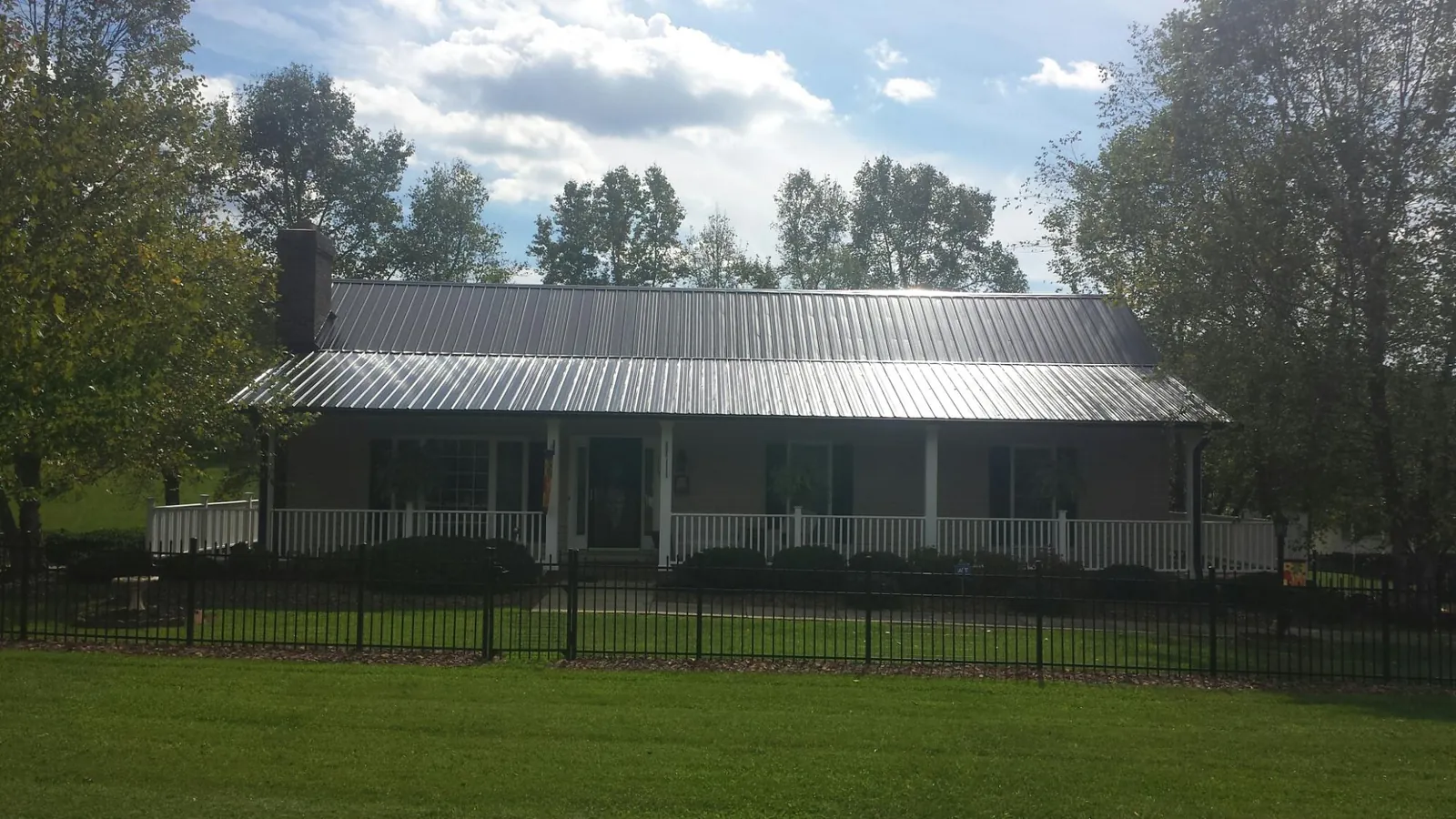 Gray metal roof on a brick ranch with a full width front porch — Gutter Guard Installation work by our crew in San Lorenzo